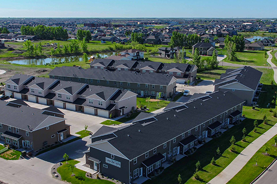 drone view of townhomes, shadow wood townhomes, west fargo townhomes, green grass, pond